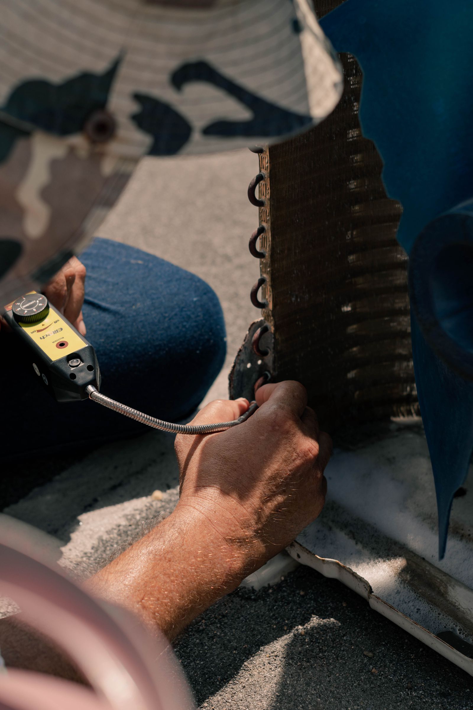 HVAC technician carefully repairing an outdoor air conditioning unit
